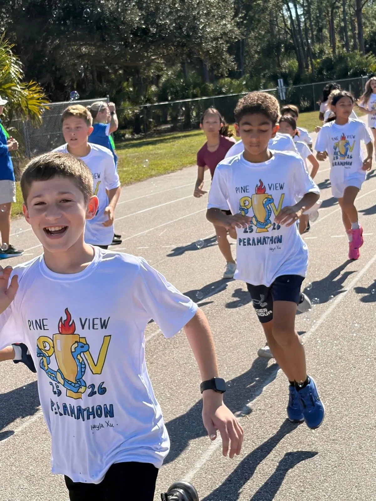 Students running, grade-level competitions, volunteers, cheering